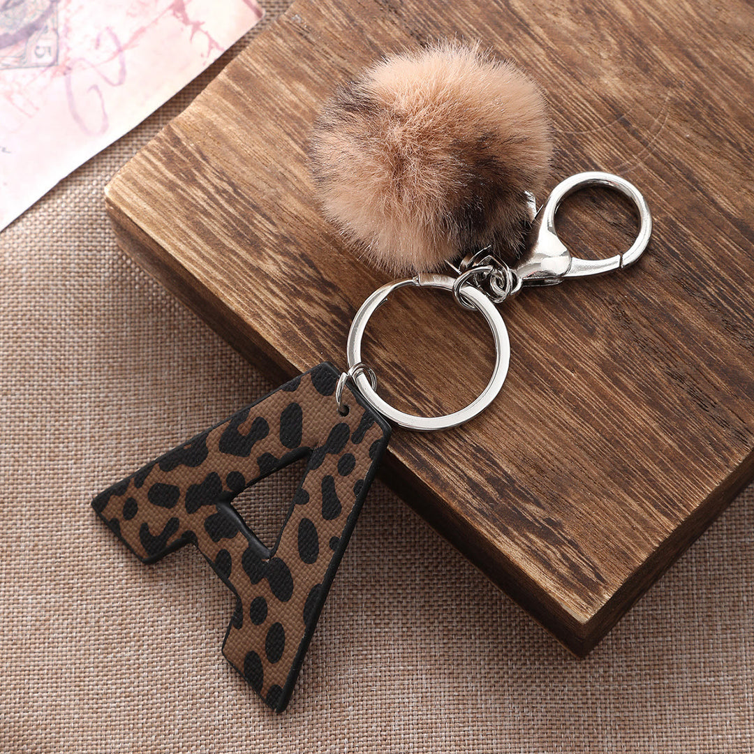 Schlüsselanhänger aus Leder im Western-Stil mit Leopardenmuster und Plüschball - image 1